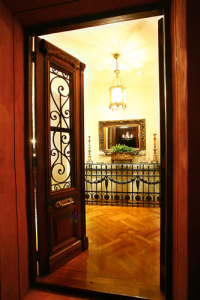 Recycled French Oak Wine Barrel Flooring, Antique Iron Insert Doors, Iron Console, Antique Mirror, Antique Chandelier, Antique Planter Box and Candlesticks